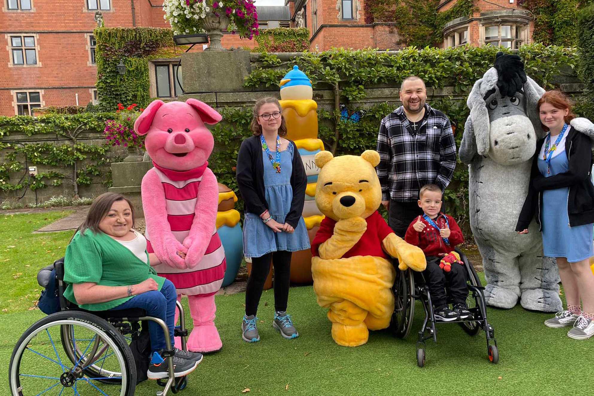 Lincoln posing in the gardens of the hotel with Winnie the Pooh and other Disney characters.