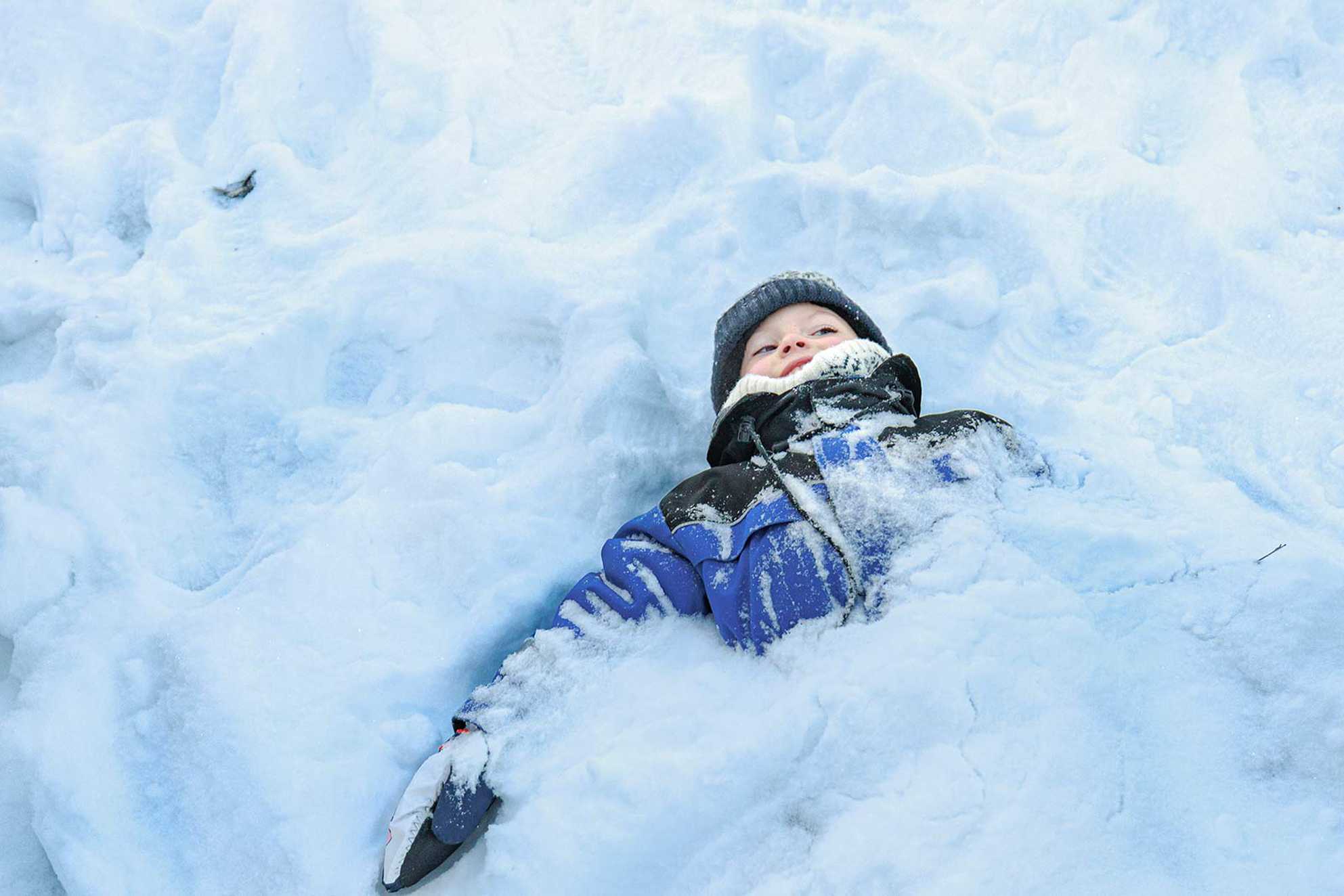 James almost completely buried in snow, with just his head and shoulders poking out.